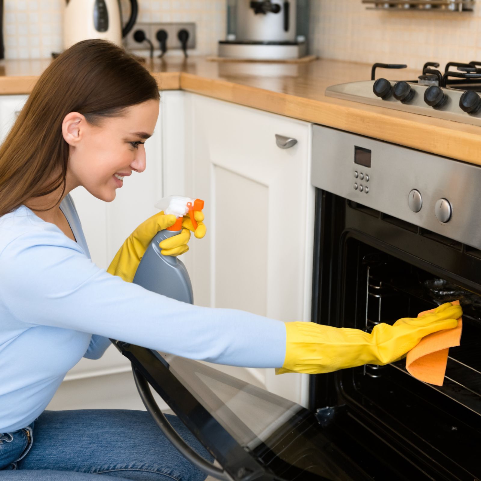 Haushaltshilfe reinigt Backofen